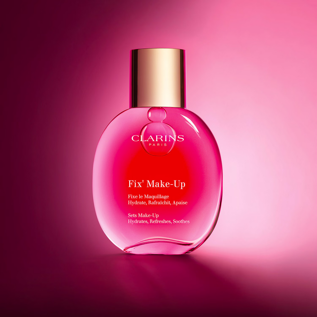 Brume fixatrice Clarins Fix’ Make-Up 50 ml sur un fond rose lumineux.