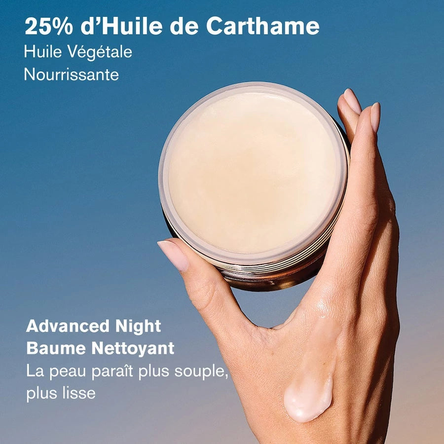 Main présentant le baume nettoyant Estée Lauder Advanced Night ouvert, montrant sa texture fondante et sa formule contenant 25 % d'huile de carthame.