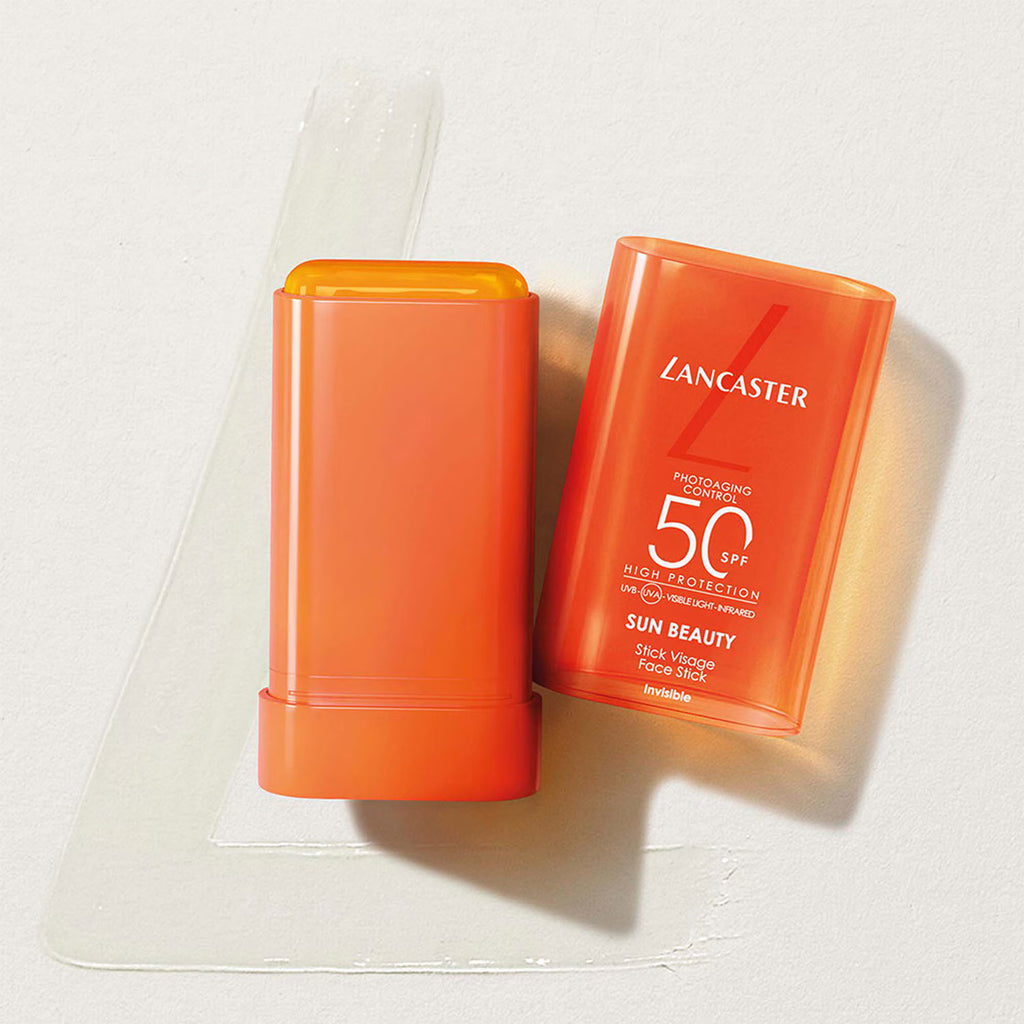 Stick Lancaster Sun Beauty SPF 50 ouvert, avec son capuchon orange et une trace de texture translucide